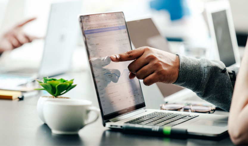 Man pointing at laptop screen showing an analytics report