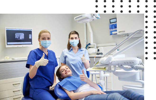 dentists and a dental patient doing a thumbs up sign inside the clinic