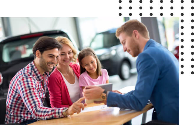 car dealer showing parents and daughter a tablet