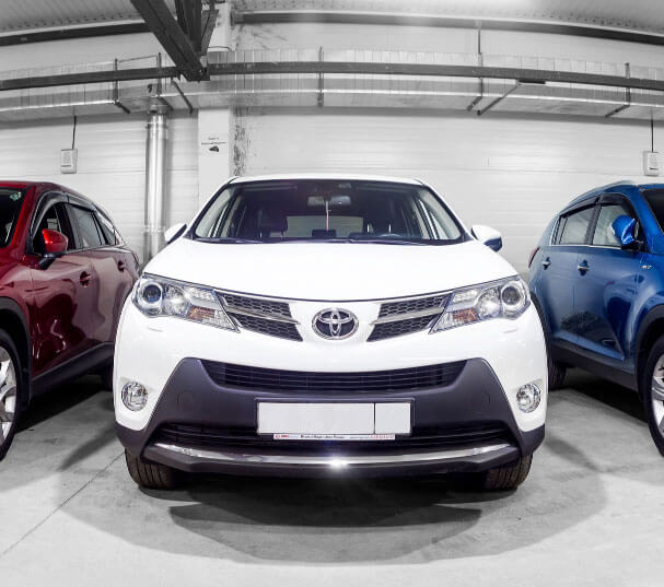 Parked white car with blue and red cars beside