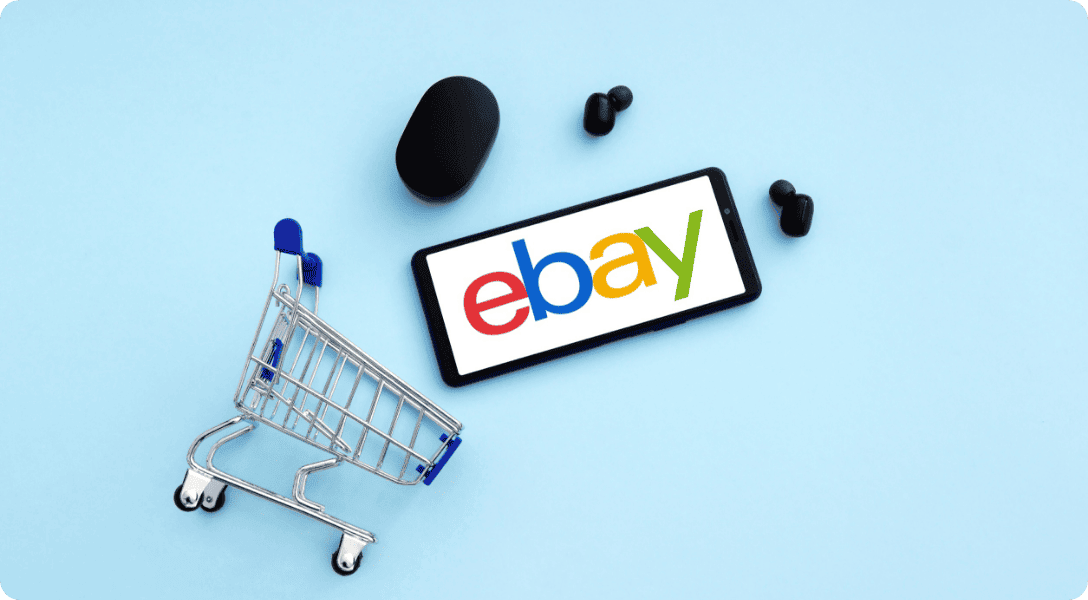 mini shopping cart and a cellphone with eBay logo flashed on screen