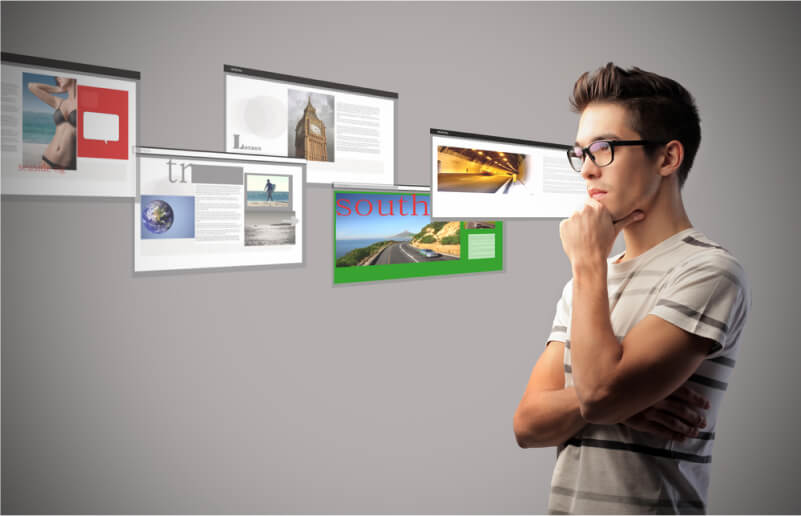 A young man wearing glasses and a striped t-shirt thoughtfully examining a floating display of various images, including landscapes and architectural photos.